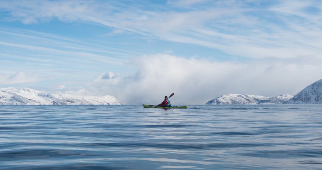Guests kayaking among ice floes during a winter kayaking experience at Ringstad Resort