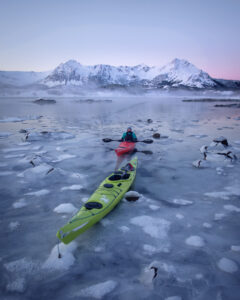 Guests kayaking among ice floes during a winter kayaking experience at Ringstad Resort