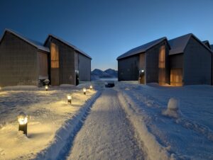 Snow-covered cabins with soft outdoor lighting at Ringstad Resort in winter